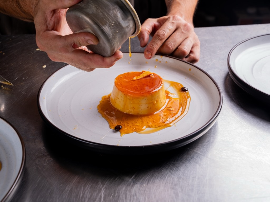 Chef pouring caramel over a flan