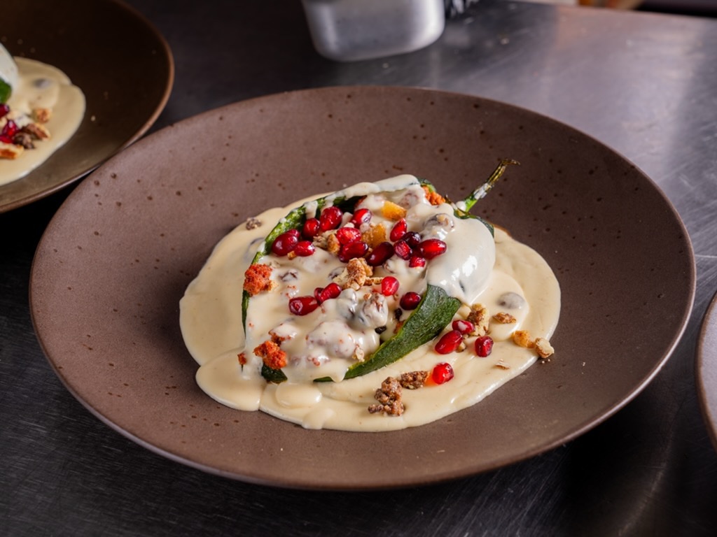 Chile en nogada with walnut cream sauce, pomegranate seeds and pecans