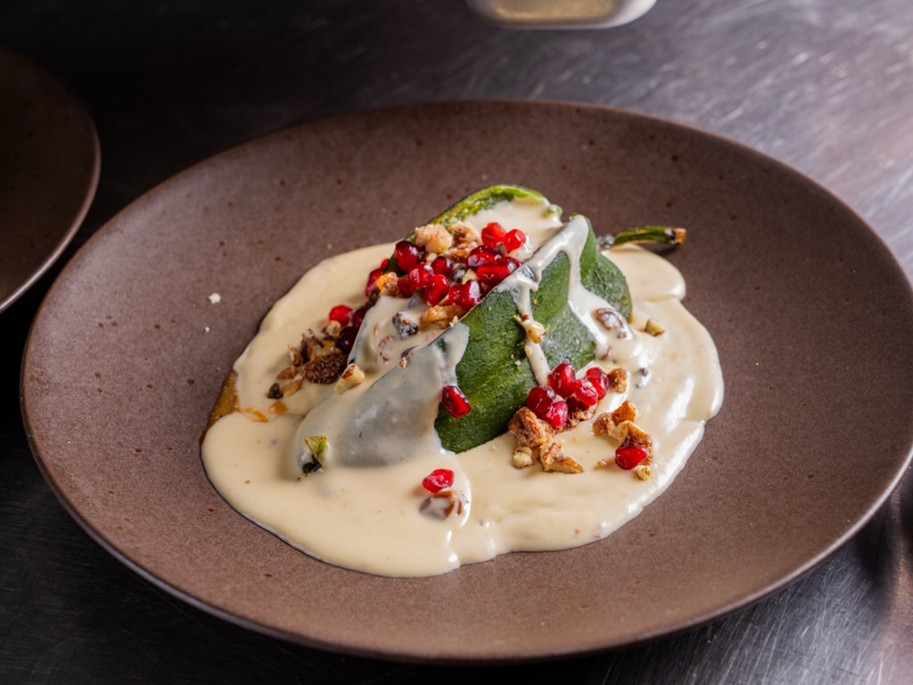 Chile en nogada: poblano pepper in creamy walnut sauce topped with pomegranate seeds