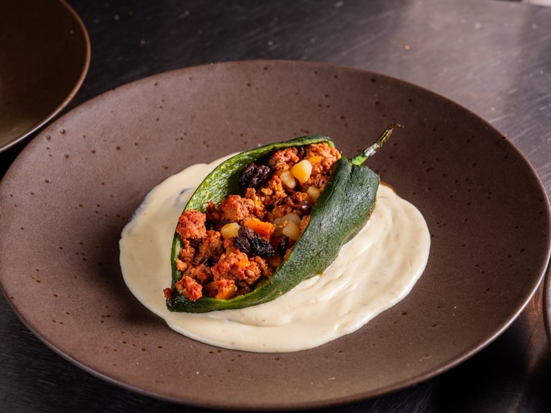 Poblano pepper stuffed with picadillo over a creamy white sauce