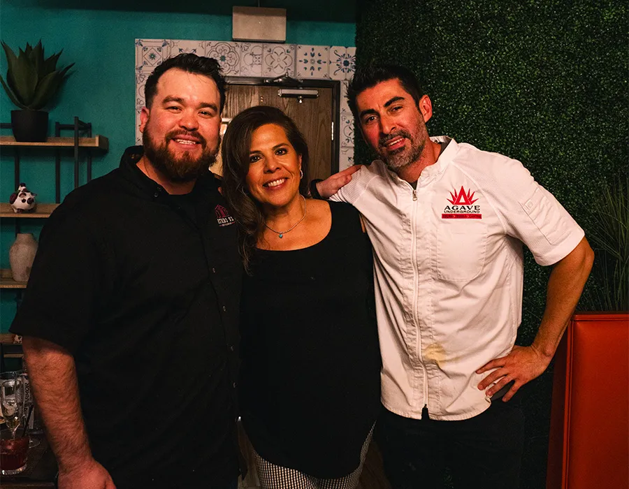 Chefs and a guest posing together in the restaurant