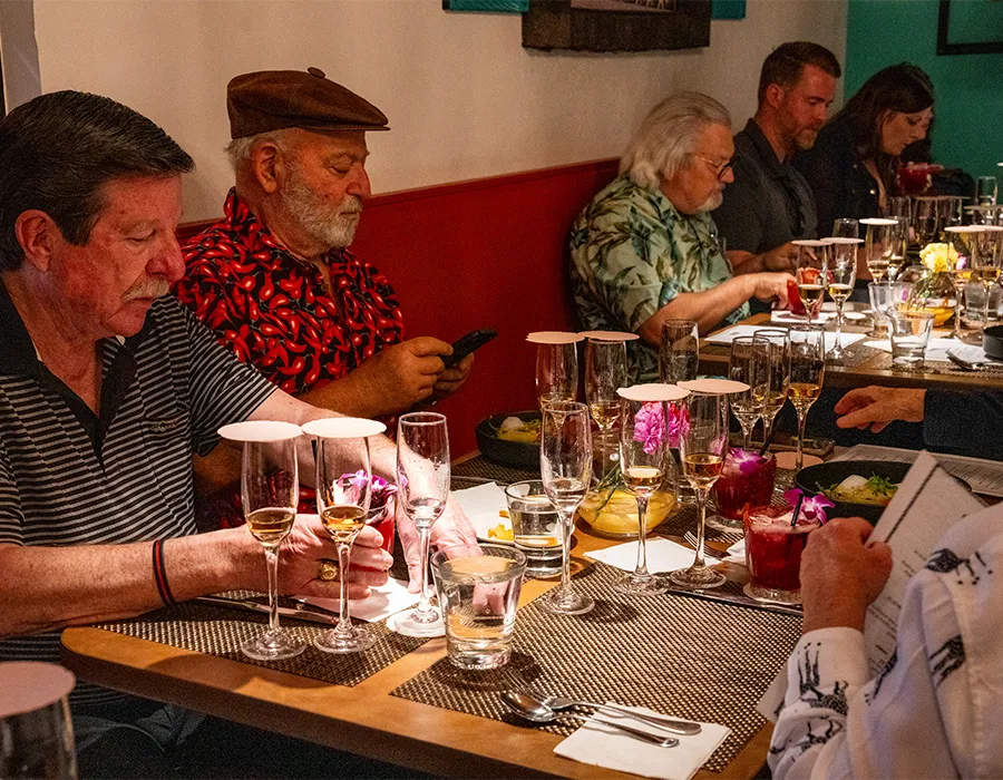Guests enjoying a paired dinner with wine glasses at the table